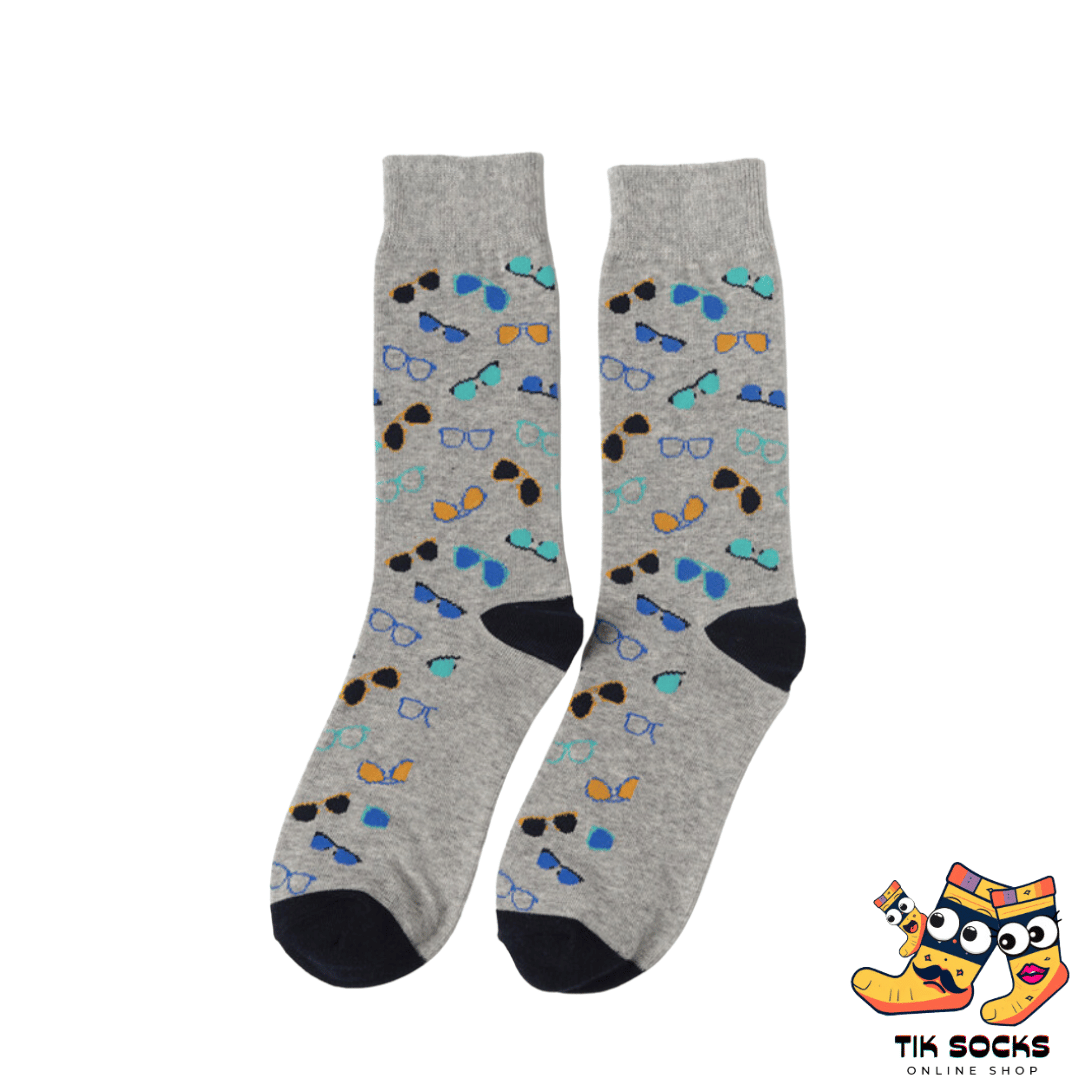 Men's and women's socks adorned with various styles of eyeglasses, from round to square frames, set against a patterned background