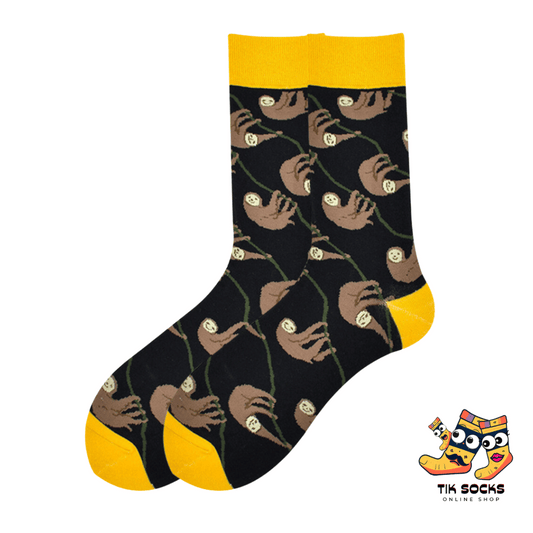 Men's and women's socks featuring detailed illustrations of folivora (sloths) hanging from tree branches and lounging, set against a naturalistic background