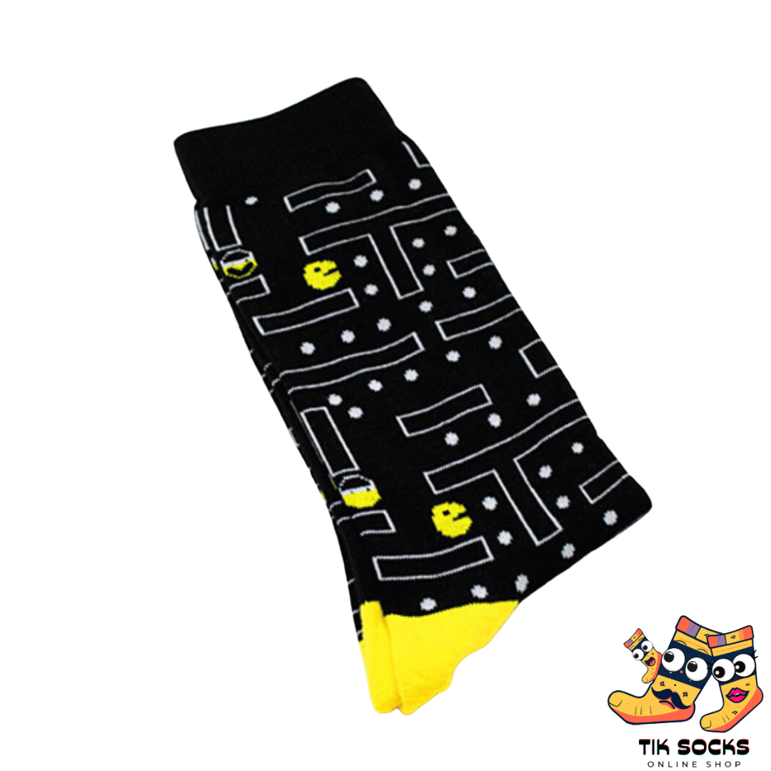 Men's and women's socks featuring colorful graphics from the classic Pac-Man game, including Pac-Man, ghosts, and pixelated fruit, set against a maze-patterned background