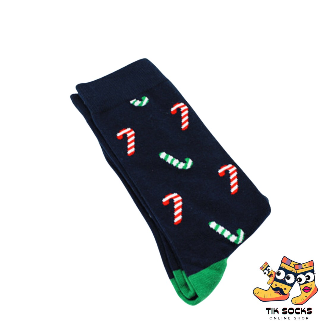 Men's and women's socks decorated with red and white striped Christmas candy canes amidst festive greenery